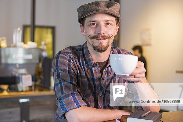 Kaukasischer Mann trinkt Kaffee in einem Cafe