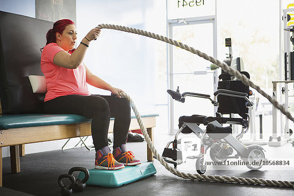 Behinderte Frau macht Physiotherapie im Fitnessstudio