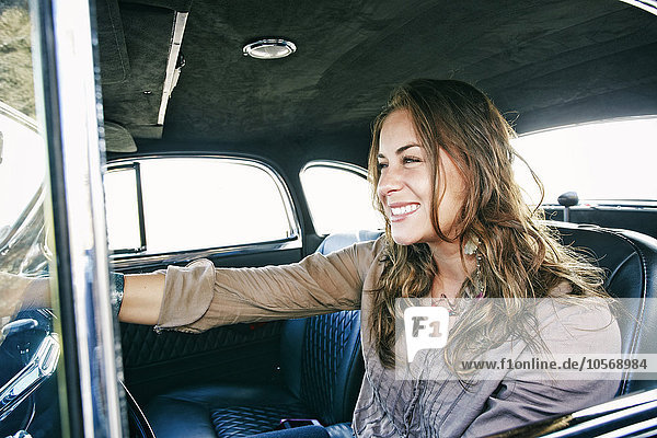 Mixed race woman driving vintage car