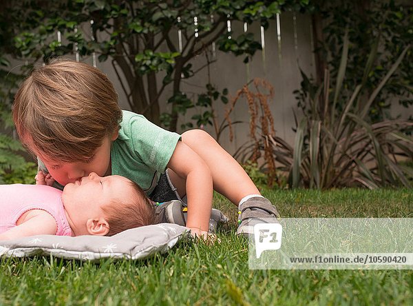 Kleiner Junge  küssende kleine Schwester  im Freien