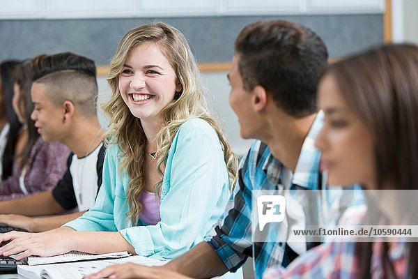 Reihe von jugendlichen Gymnasiasten lächelnd in der Computerklasse