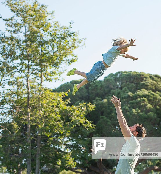 Father throwing son in air  outdoors
