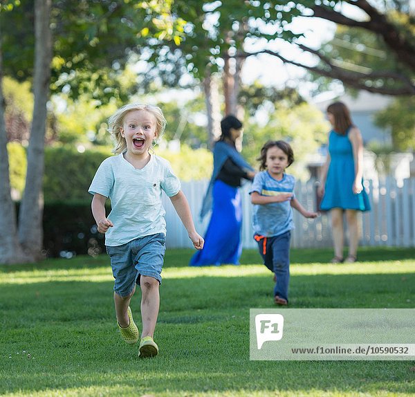 Zwei kleine Jungen beim Rennen im Garten