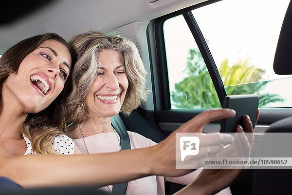 Senior Frau und Tochter unter Smartphone Selfie im Auto