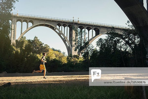 Joggerlauf  Bogenbrücke im Hintergrund  Arroyo Seco Park  Pasadena  Kalifornien  USA