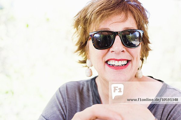 Porträt einer glücklichen reifen Frau mit Sonnenbrille