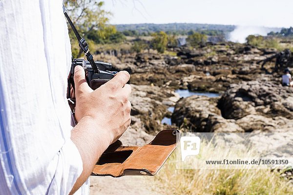 Cropped shot of man using camera near Victoria Falls  Zambia
