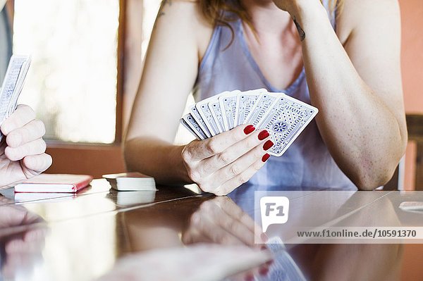 Ausschnitt einer jungen Frau beim Kartenspielen