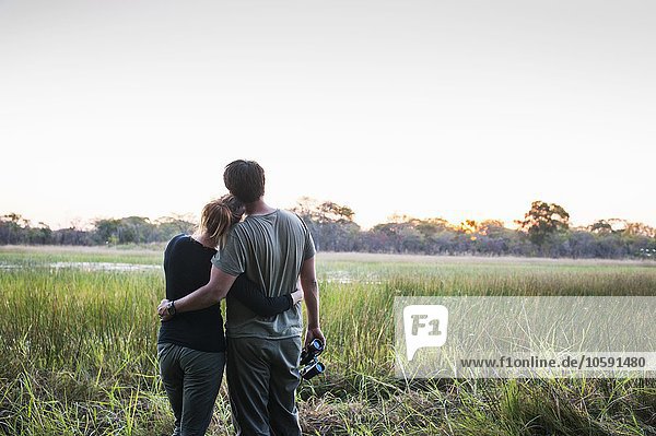 Romantic couple on safari looking out at landscape  Kafue National Park  Zambia