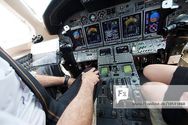 Schnappschuss von männlichen und weiblichen Piloten Knie im Cockpit des Privatjets