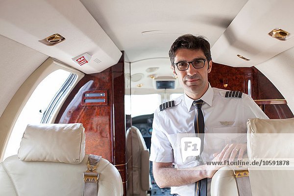 Portrait of male pilot in cabin of private jet