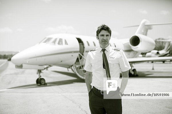Black and white portrait of male private jet pilot at airport
