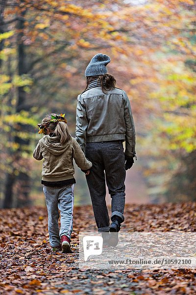 Mutter und Tochter wandern im Herbstwald