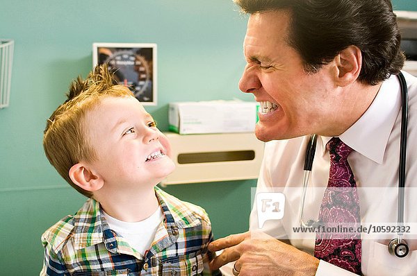 Male doctor looking at young boy's teeth