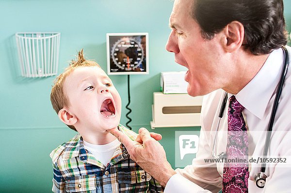Young boy having check-up in doctor's office  doctor looking in boy's mouth