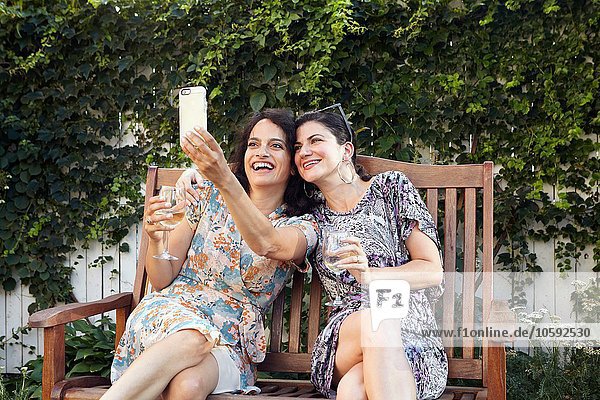 Zwei Frauen nehmen für Smartphone Selfie auf der Terrasse