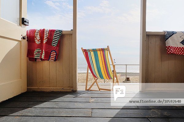 Leerer Liegestuhl vor der Strandhütte Rückansicht