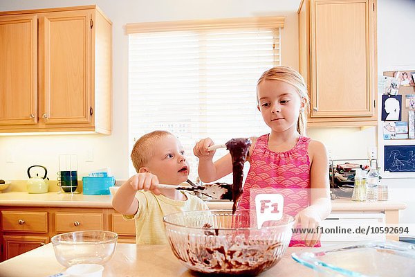 Geschwister schmelzen Schokolade in der Rührschüssel