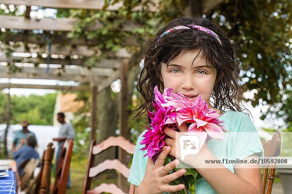 Portrait of young girl holding flowers  outdoors