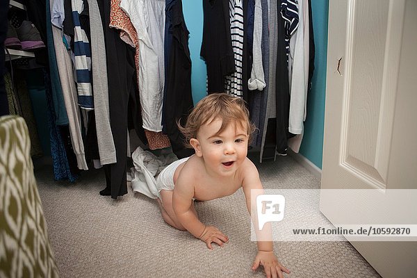 Baby boy crawling  emerging from wardrobe