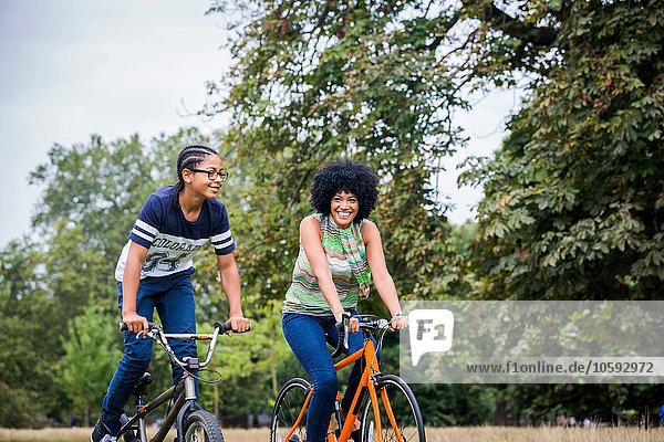 Mother and son riding on bicycles smiling