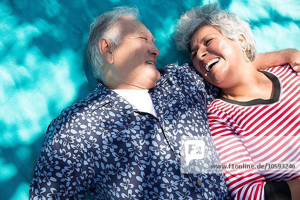 Seniorenpaar auf Picknickdecke liegend  erhöhte Aussicht