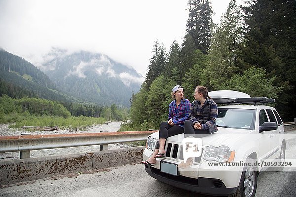 Hikers chatting on bonnet of vehicle  Lake Blanco  Washington  USA