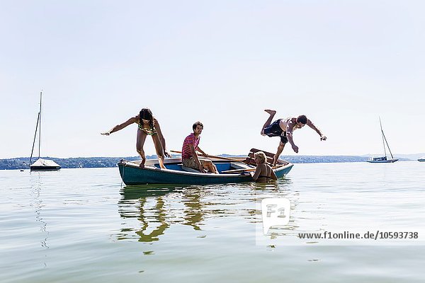 Freundeskreis taucht vom Boot in den See  Schondorf  Ammersee  Bayern  Deutschland