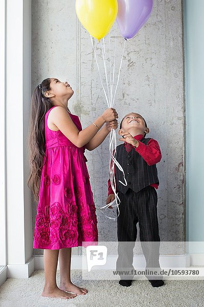 Young girl and boy  holding balloons