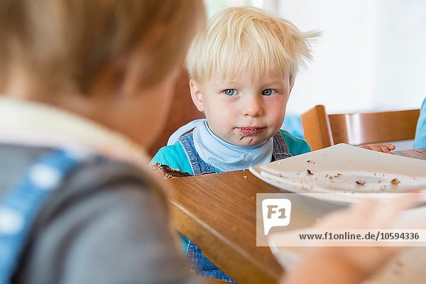 Male and female toddler at tea table