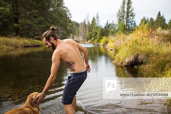 Junger Mann beim Paddeln mit Hund im Fluss  Lake Tahoe  Nevada  USA