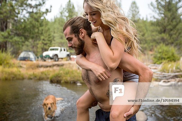 Junger Mann  der seiner Freundin einen Huckepack-Fluss überquert  Lake Tahoe  Nevada  USA