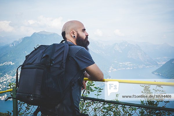 Mittlerer Erwachsener Mann auf dem Balkon mit Blick auf den Luganer See  Schweiz