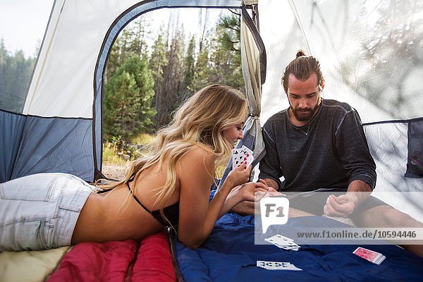 Young couple playing cards in tent  Lake Tahoe  Nevada  USA