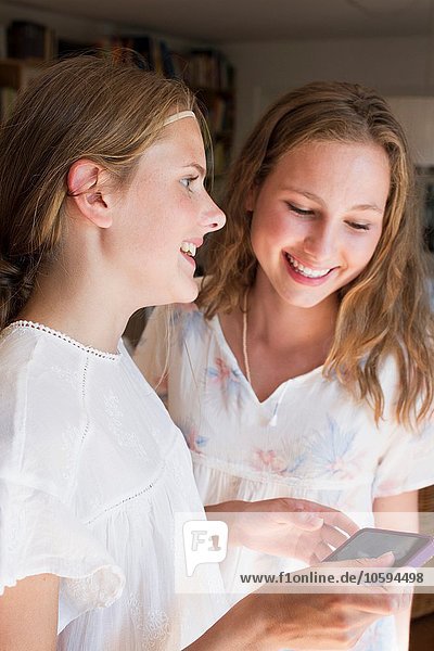 Zwei Teenager-Mädchen beim Lesen von Smartphone-Texten