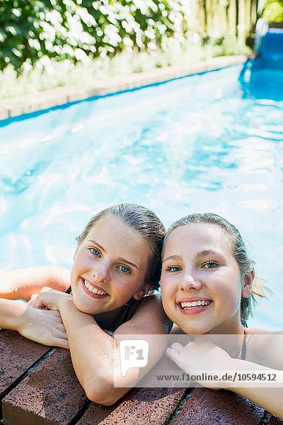 Porträt von zwei Teenagern  die sich am Pool lehnen
