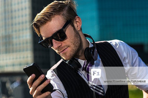 Jungunternehmer vor dem Büro beim Lesen von Smartphone-Texten New York USA