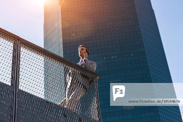 Tiefblick auf einen jungen Geschäftsmann der auf einem Smartphone auf dem Stadtbalkon plaudert New York USA