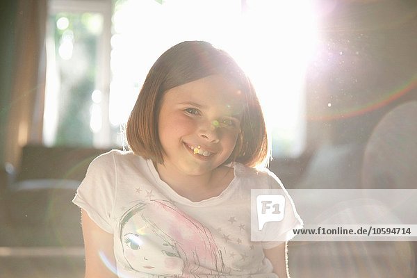 Sonnenbeleuchtetes Porträt des lächelnden Mädchens