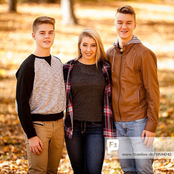 Porträt einer jungen Frau und zweier Teenager-Brüder im Herbstwald