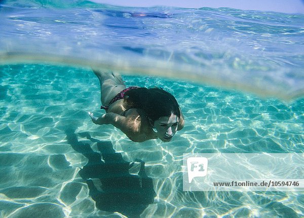 Junge Frau schwimmt unter Wasser im Meer