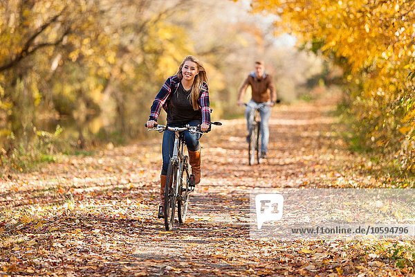 Jugendlicher Junge und erwachsene Schwester beim Radfahren im Herbstwald