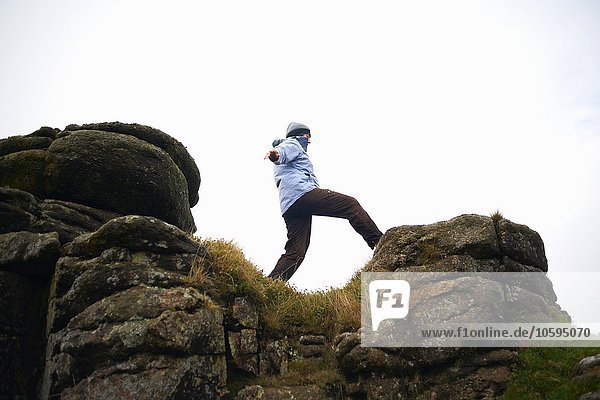 Flachwinkelansicht einer Frau auf einer Felsformation  Dartmoor  Devon  UK