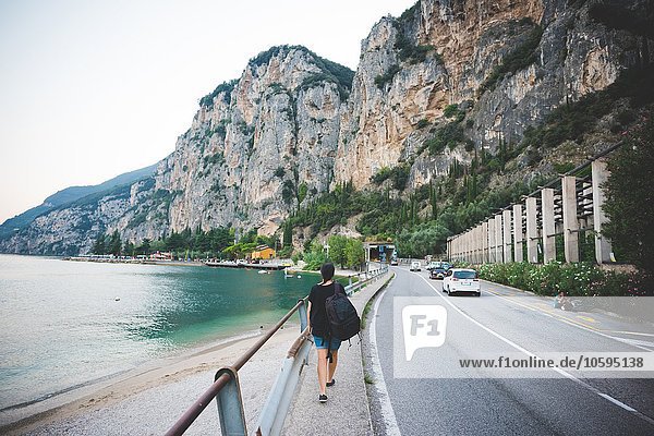 Tourist walking along road by Lake Garda  Italy