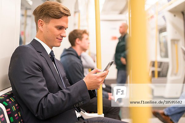 Geschäftsmann texting on tube  London Underground  UK