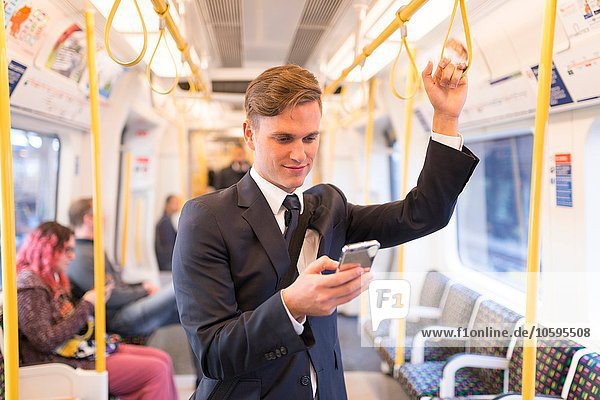 Businessman texting on tube  London Underground  UK