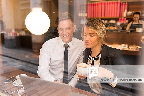 Geschäftsmann und Geschäftsfrau bei der Arbeit am Laptop im Cafe