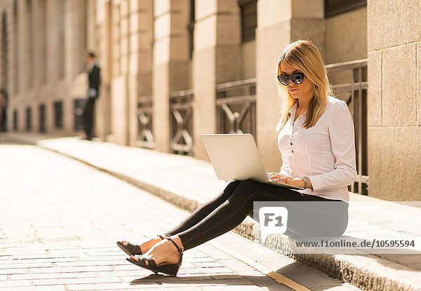 Geschäftsfrau mit Laptop am Bordstein  London  UK
