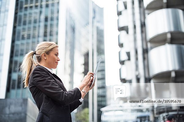 Geschäftsfrau mit digitalem Tablett in der Straße  London  UK