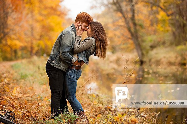 Romantic young couple on riverside in autumn
